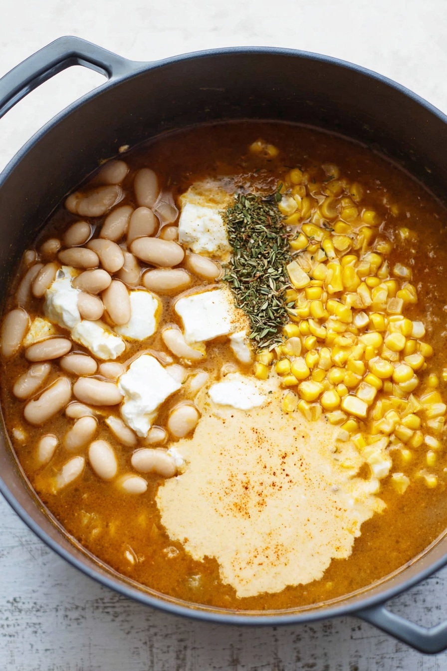 A deep blue pot holds a creamy soup with a light orange color mixed with small bits of green herbs and yellow corn. Inside the soup, shredded chicken pieces and chopped green vegetables float, with some fresh green cilantro leaves sprinkled on top. Thin slices of avocado with bright green color are neatly arranged in a fan shape near the center. A wooden spoon rests inside the pot, partially submerged in the soup, which sits on a white marbled surface with a white and blue striped cloth under it. Photo taken with an iphone --ar 2:3 --v 7