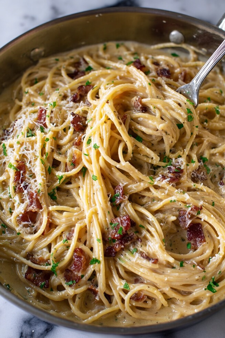 The image shows a close-up of creamy spaghetti pasta in a pan, with noodles coated in a smooth, light beige sauce. There are small pieces of browned bacon scattered throughout, adding dark reddish-brown contrast. The long, thin strands of spaghetti are twisted around a fork pushed into the pasta on the right side. Tiny bits of green herbs and grated white cheese are sprinkled on top, adding texture and color. The pan sits on a white marbled surface. Photo taken with an iphone --ar 2:3 --v 7